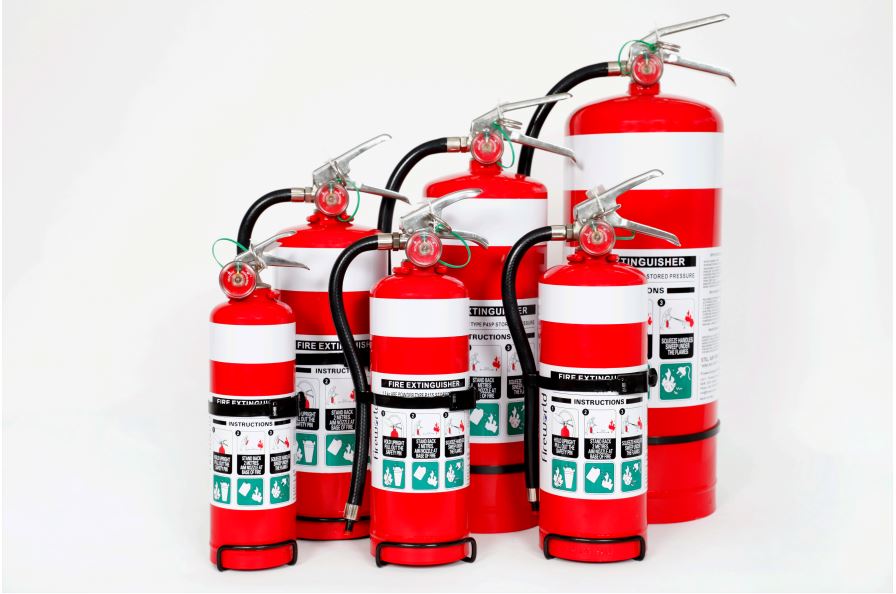 Group of fire extinguishers including ABE, CO2, foam and wet chemical types – red cylinders with labels